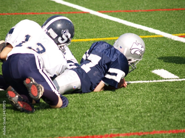 Fototapeta young football player being tackled