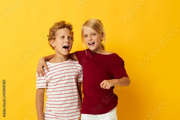 Fototapeta Cute preschool kids cuddling fashion childhood entertainment on colored background