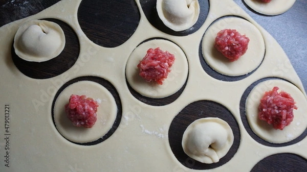 Obraz dumplings, a traditional dish of Russian cuisine, made of dough stuffed with minced meat, minced meat, cooking process, modeling, recipe