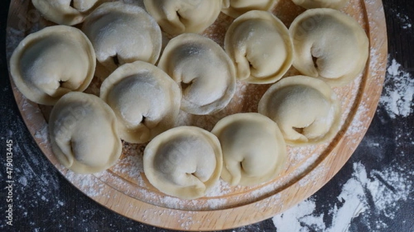 Fototapeta dumplings, a traditional dish of Russian cuisine, made of dough stuffed with minced meat, minced meat, cooking process, modeling, recipe