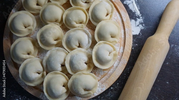 Fototapeta dumplings, a traditional dish of Russian cuisine, made of dough stuffed with minced meat, minced meat, cooking process, modeling, recipe