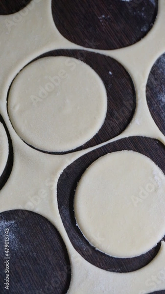 Fototapeta cooking process, modeling, recipe, dough, cut out round pieces, roll out with a wooden rolling pin, flour, dumplings