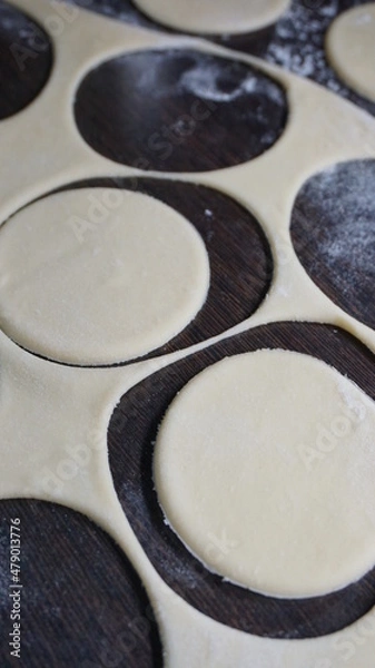 Obraz cooking process, modeling, recipe, dough, cut out round pieces, roll out with a wooden rolling pin, flour, dumplings