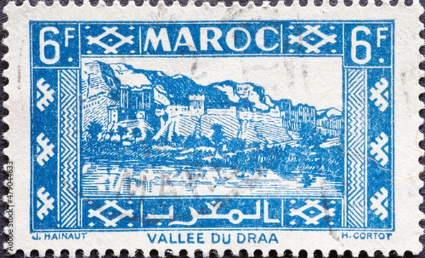 Fototapeta Morocco - circa 1946: A post stamp from the Morocco showing the Kasbah in Draa Valley.