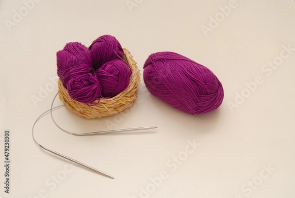 Fototapeta Balls of colored knitting threads and knitting needles on a white background. Needlework and stress relief