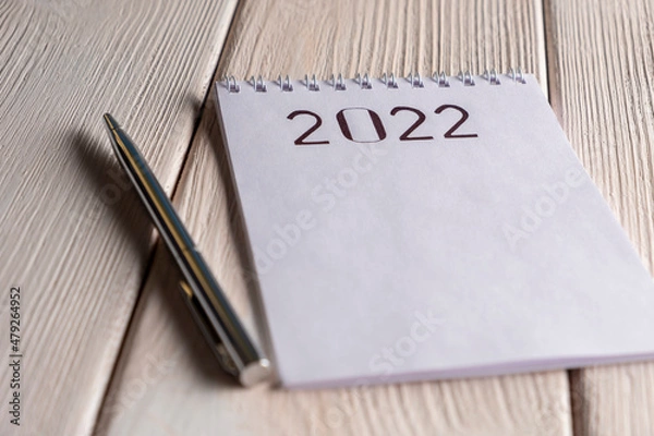 Fototapeta 2022 Goals. Notepad with pen on white wooden table.