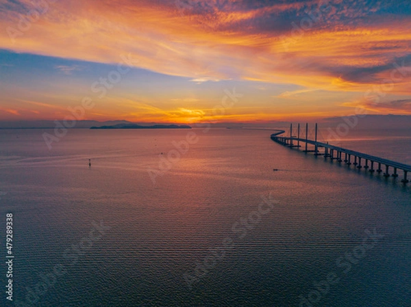 Fototapeta View of the bridge at sunrise which stands on the sea and connects the island and the mainland. It is the longest bridge in Malaysia