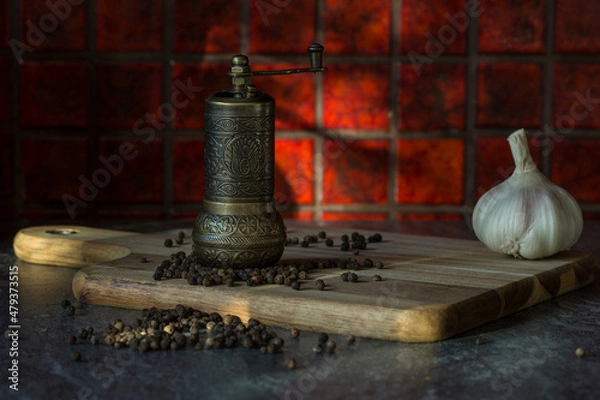 Fototapeta Turkish Grinder, Spice Grinder, Salt Grinder, Pepper Mill on a wooden board with loose black pepper corns