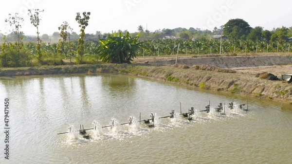 Obraz Aerial view of water turbines machine on lake, pond or river in farm field in industry factory. Power, sustainable green clean energy, and environment concept. Nature innovation.