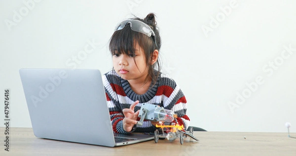 Fototapeta The little girl asian building robotic car in science lesson in the house . Which increases the development and enhances learning skills gifted brilliant children working with technology.