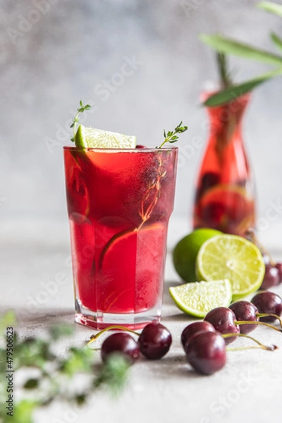 Obraz Lemonade or non-alcohol cocktail with cherry and lime, grey concrete background. Summer refreshment drink.