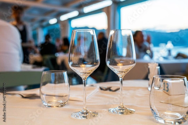 Fototapeta Table settings for fine dining with and glassware, beautiful blurred background. Diner at the shore of the Mediterranean Sea. Food concept.