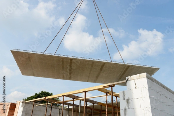 Fototapeta Precast Floor Slab flies through the air in front of bue sky.