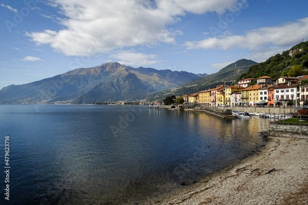 Fototapeta Lake como , bay of Domaso, Italy, typical houses of the village with mountains in background andy blue sky