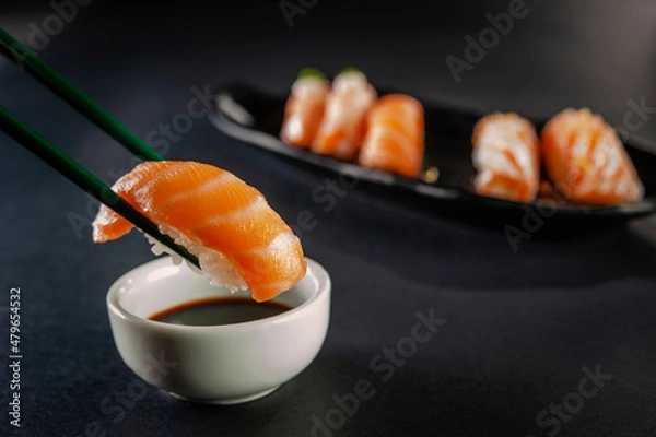 Fototapeta Salmon onigiri on chopsticks.