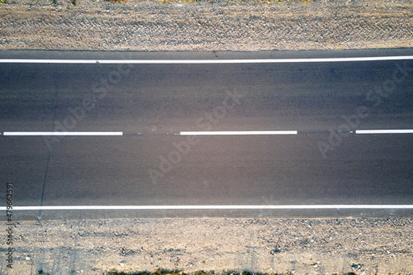 Fototapeta Aerial view of empty intercity road at sunset. Top view from drone of highway in evening