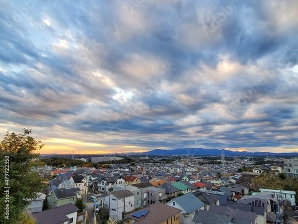 Obraz 街並みを見下ろすダイナミックな夕焼けの模様雲
