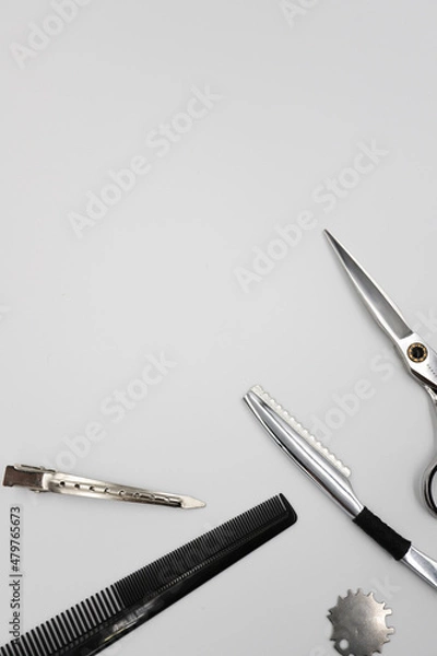 Fototapeta a set of professional combs, scissors, razors and hairpins unfolds on a light background