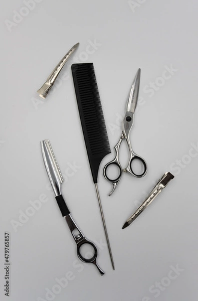 Fototapeta a set of professional combs, scissors, razors and hairpins unfolds on a light background