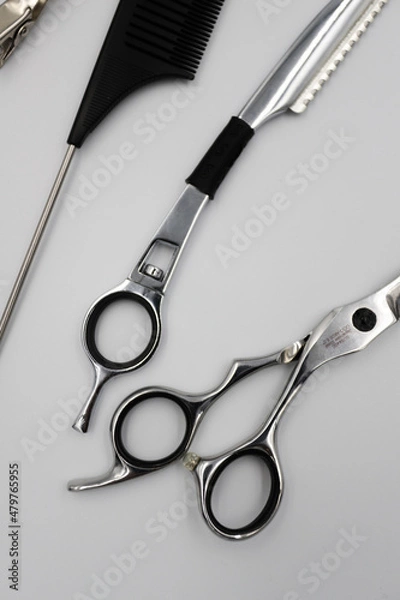 Fototapeta a set of professional combs, scissors, razors and hairpins unfolds on a light background