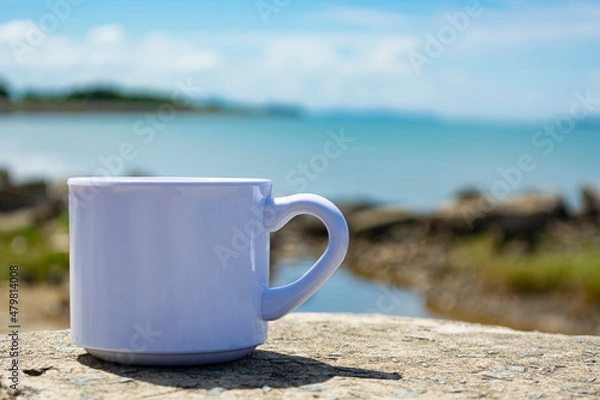 Fototapeta Empty white cup on blurred beach background