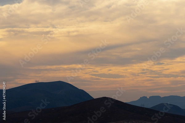 Fototapeta Golden time in cloudy skies and blue mountains
