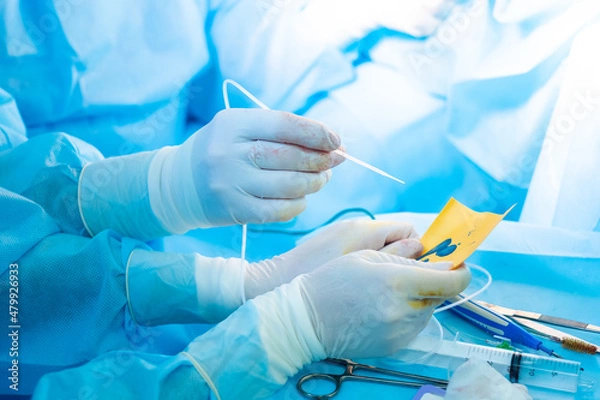 Fototapeta The surgeon's hand in a sterile glove holds a fibrin glue dispenser. Fibrin glue is an innovative medical drug for hemostasis.