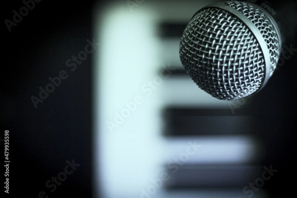 Fototapeta Microphone over piano keys in dim light