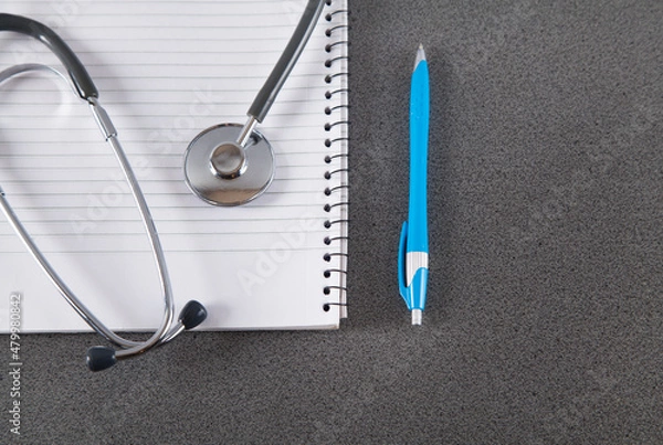 Obraz Stethoscope, notebook and pen on gray background.
