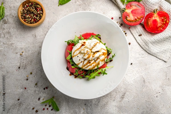 Obraz Salad with buratta cheese and tomatoes on plate on grey concrete table top view
