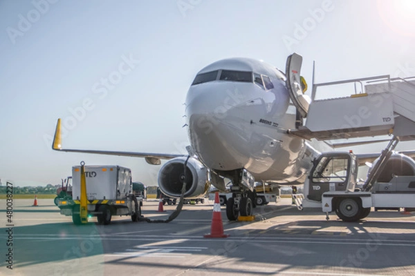 Fototapeta A twin-engine jet plane stands at the airport in the parking lot at summer 