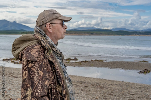 Fototapeta Portrait of a pensive elderly man on the seashore, looking to the side.thinking about the meaning of life
