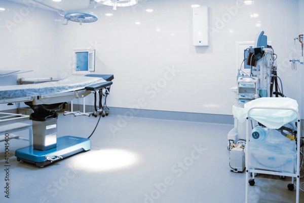 Fototapeta Empty operating room in a hospital. Surgical equipment with operating table. Medical device for emergency patient in blue tone style. Blank Emergency Surgery Room. Clinic interior for background.