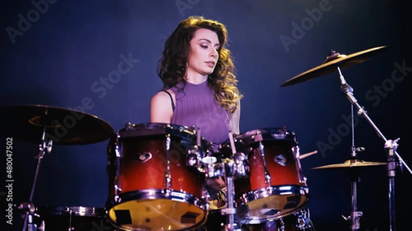 Fototapeta pretty drummer playing on drums during performance on stage.