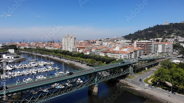 Fototapeta The Gustave Eiffel Bridge over the river Lima in Viana do Castelo. Aerial panoramic cityscape view of Viana and the Marina.