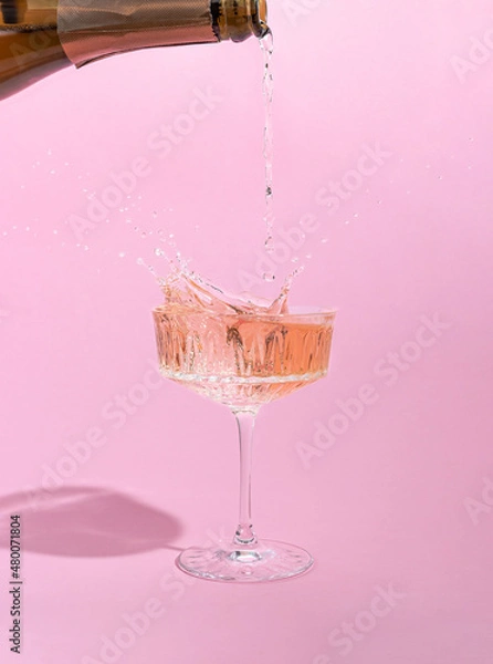 Fototapeta Pink champagne pouring in a glass. Creative minimal concept