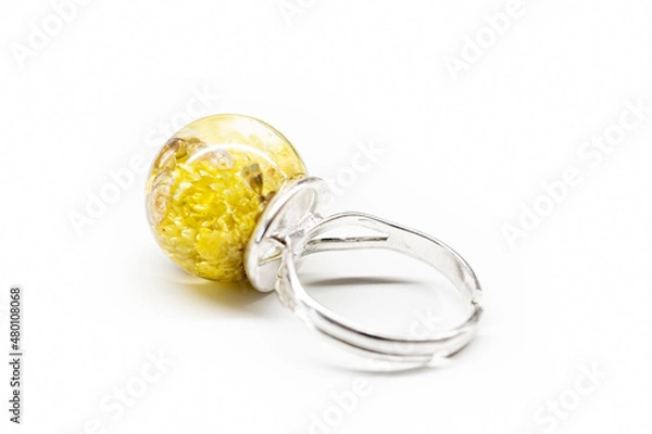 Obraz Yellow flower ring with resin. Cute piece of handmade jewelry. Natural dwarf everlast blooms collected in Poland. Selective focus on the details, blurred background.