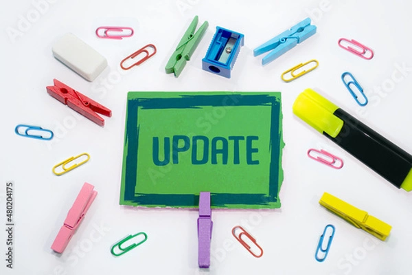 Fototapeta Text sign with Update written paper clips, clips stationary in background.