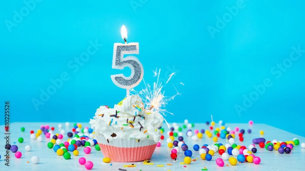 Fototapeta Beautiful congratulations on the birthday of a five-year-old child on a blue background, a card for 5 years happy birthday copy space. Festive background with cream cake