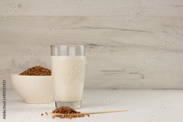 Fototapeta Dairy free buckwheat milk in a glass and buckwheat grains in a bowl