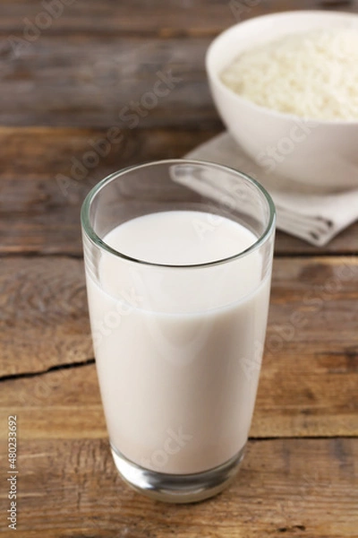 Fototapeta Dairy free rice milk in glasses and rice grains in a bowl on wooden background