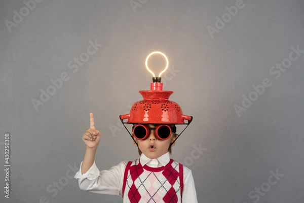 Fototapeta Smart child wearing funny helmet with illuminated lightbulb