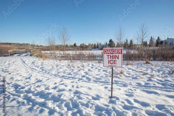 Fototapeta thin ice sign with footprints in the snow
