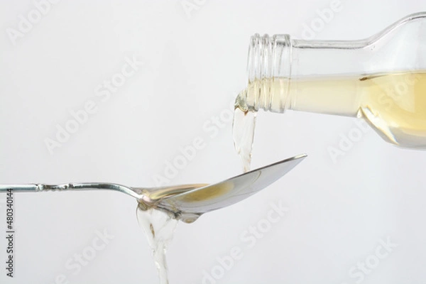 Obraz Pouring apple cider vinegar in a spoon