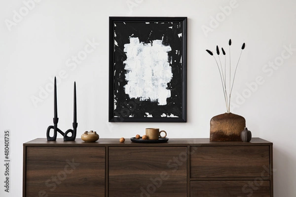 Fototapeta Creative composition of modern living room interior design with mock up poster frame, brown commode, vases, candlestick and personal accessories. White wall. Copy space. Template.