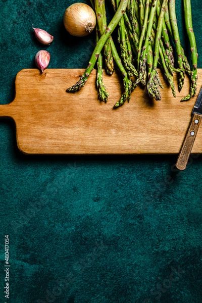 Obraz Asparagus, onion and garlic over cutting board. Food ingredients concept. Copy space, studio shot.