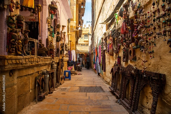 Fototapeta A narrow street with local artifacts for sale within Jaisalmer fort, Rajasthan, India.