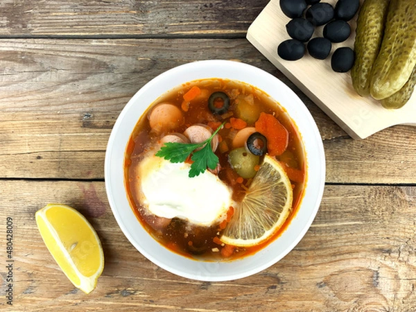 Fototapeta Traditional russian meat soup Solyanka in a bowl on wooden background