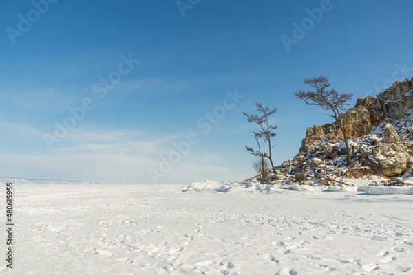 Fototapeta Sacred Cape Burkhan on Olkhon Island in winter. View from the ice of frozen Lake Baikal on a sunny day