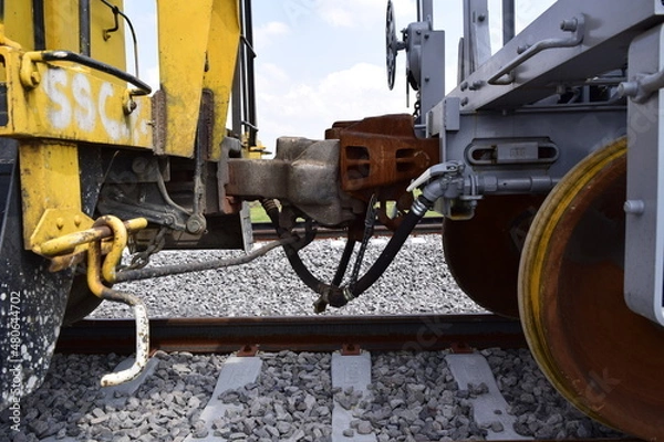 Fototapeta Parked train carriages zooming in on the wheels, zooming in on the hitch between carriages, carriages on a curve